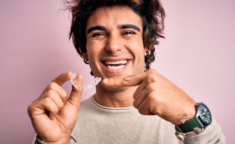 man smiling with Invisalign retainer